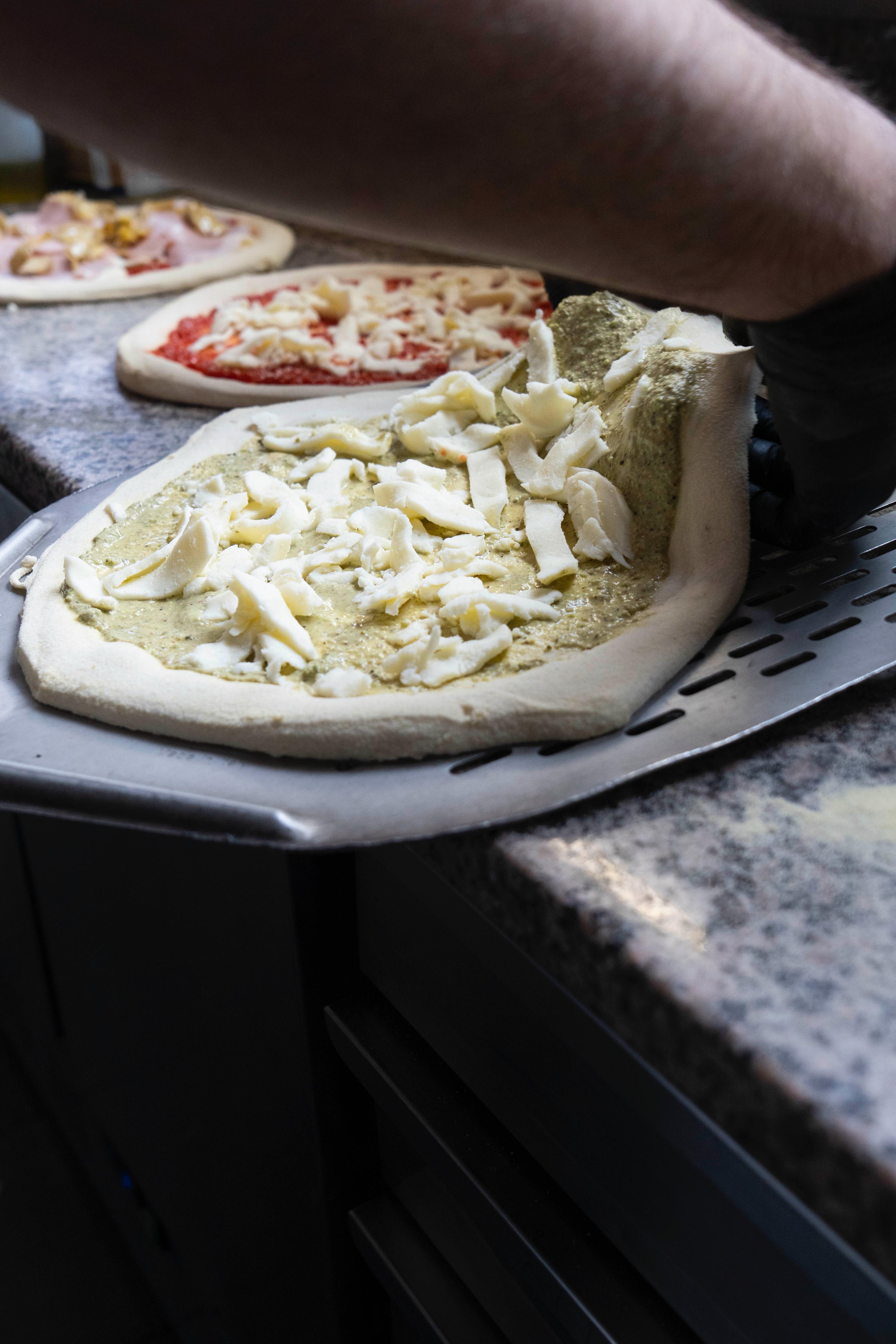 Pizza's klaarmaken voor de oven bij Kalura, Antwerpen