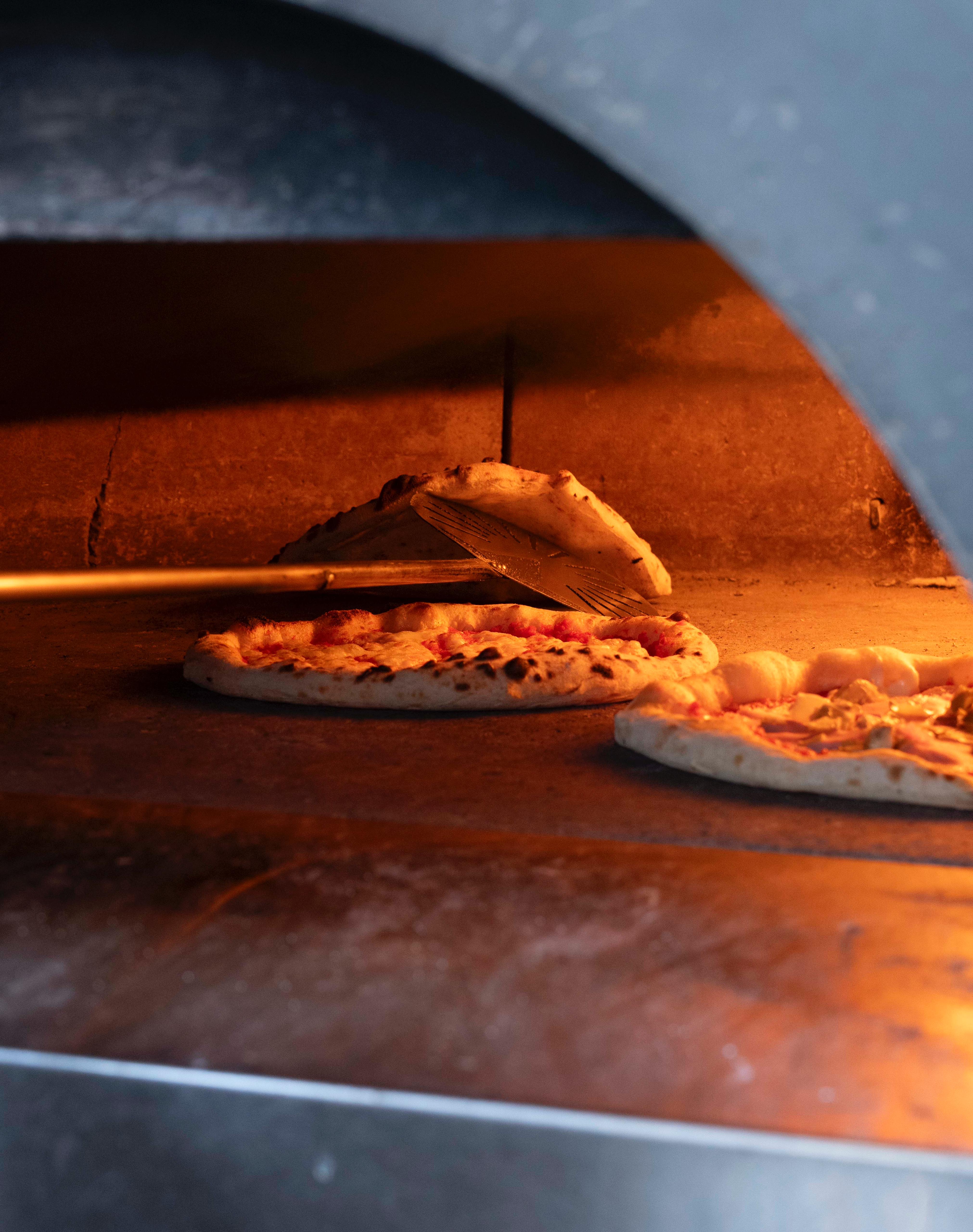 Pizza draaien in de oven bij Kalura, Antwerpen